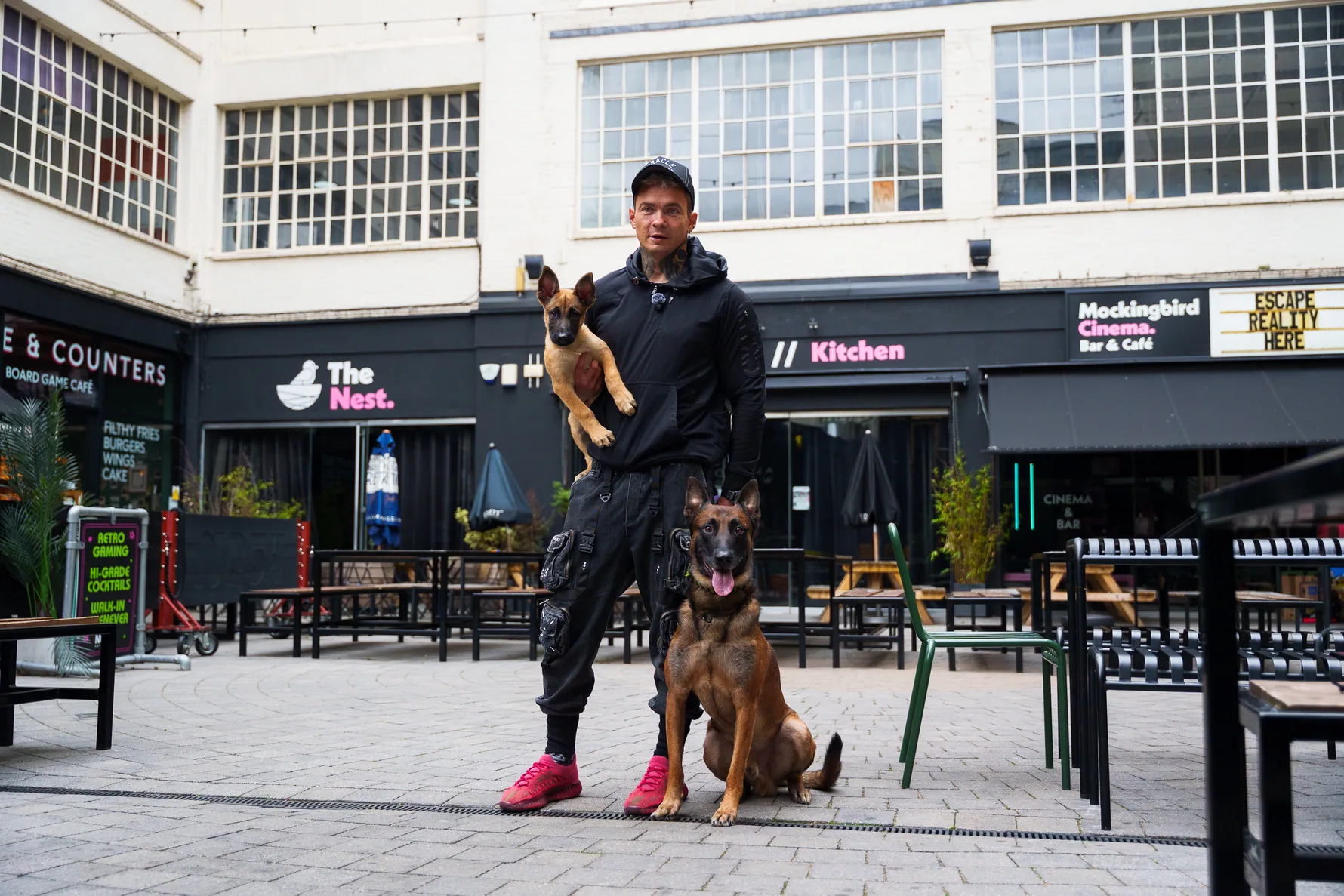 Andrejus and his two dogs posing in a Birmingham courtyard