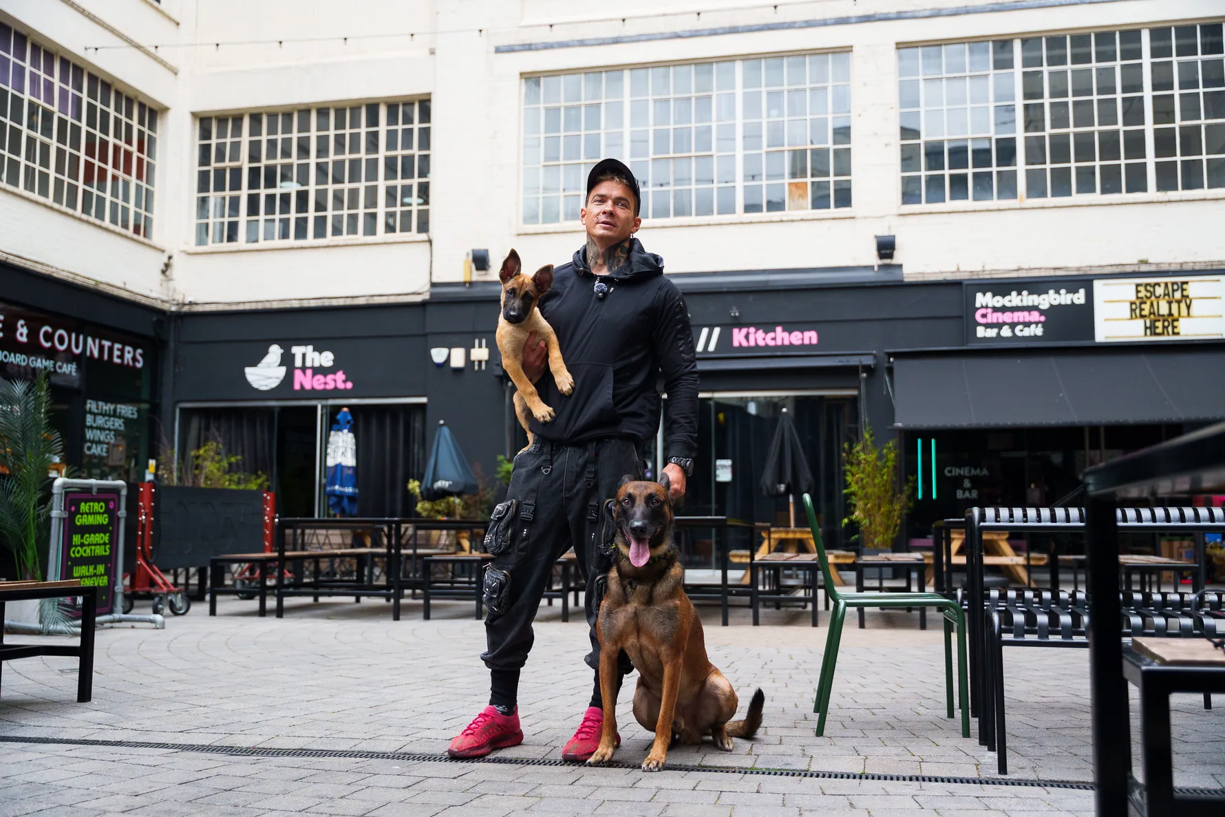 Andrejus with two working dogs in a Birmingham courtyard