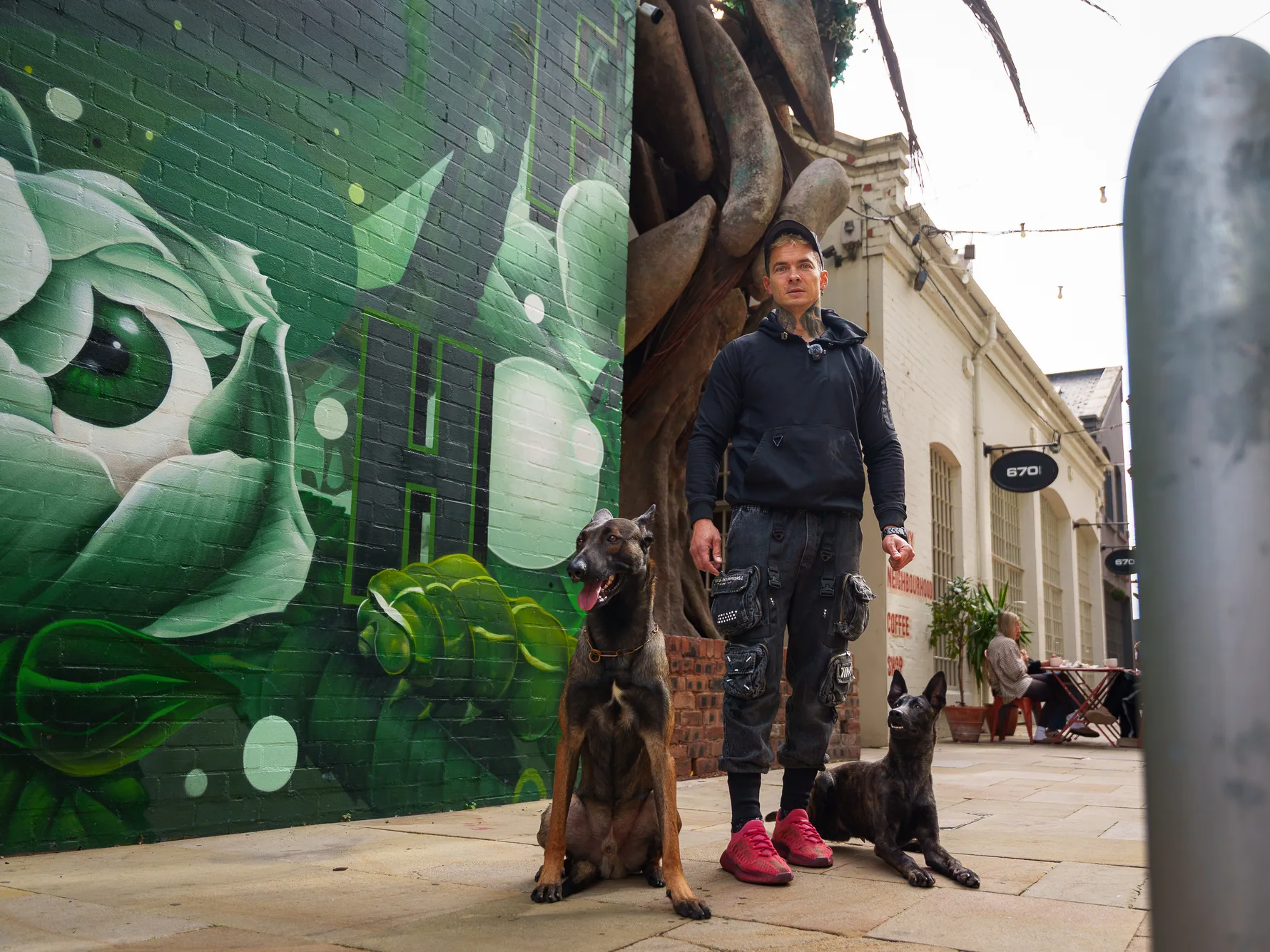 Andrejus with his dogs during public-access training beside street art