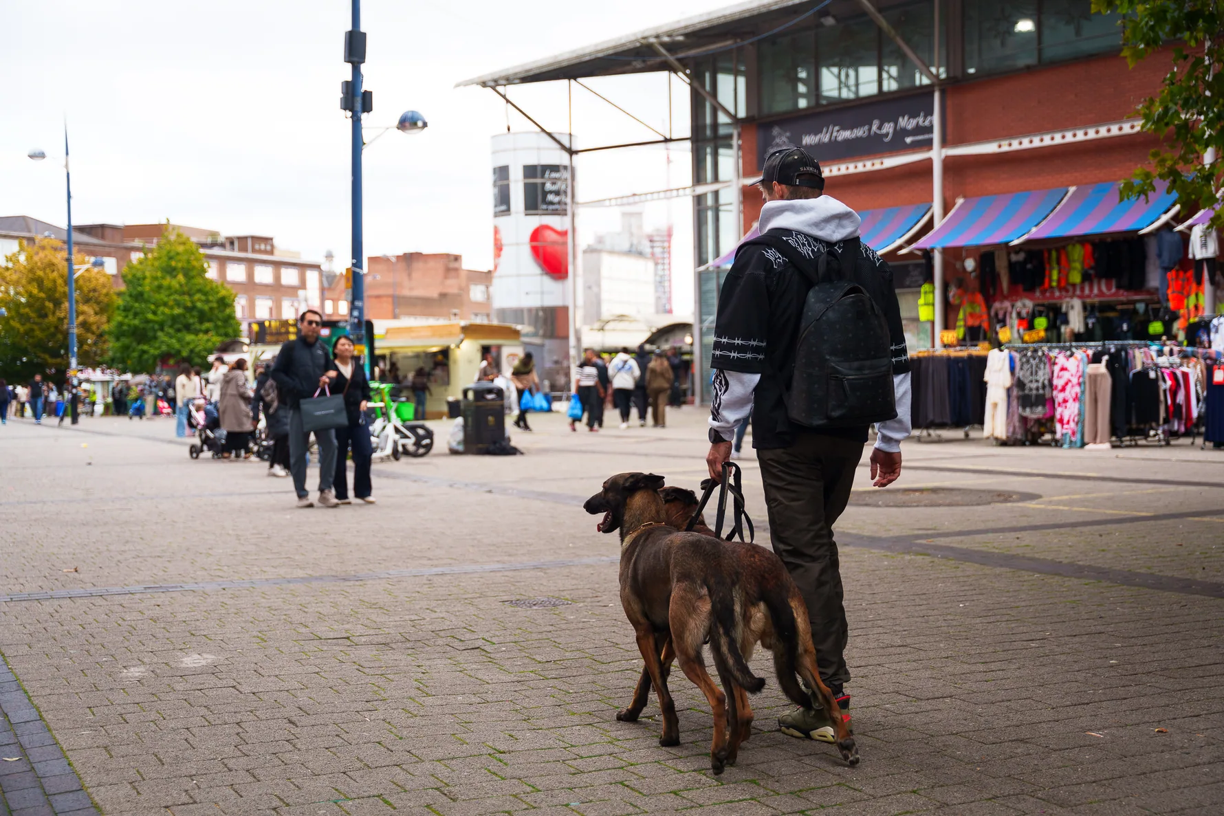 Dog and handler navigating a busy Birmingham pedestrian street
