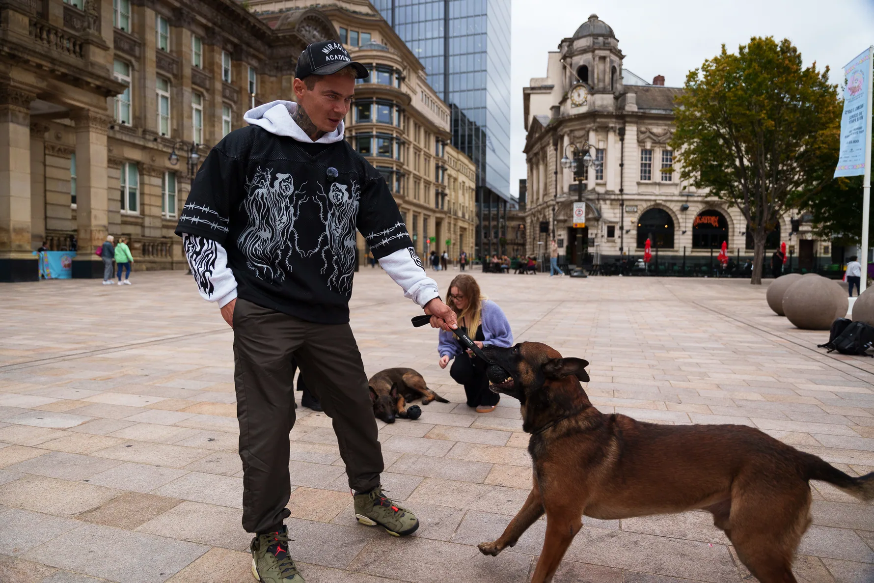 Andrejus rewarding a dog in an open city square