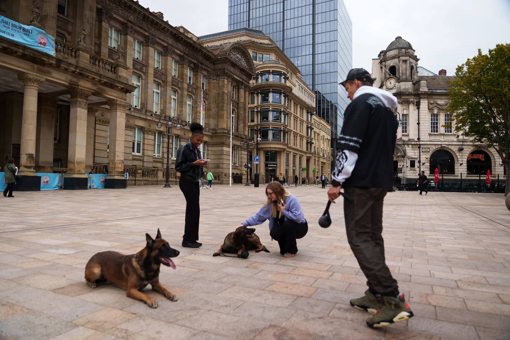 Dog training with distractions in a broad pedestrian city square