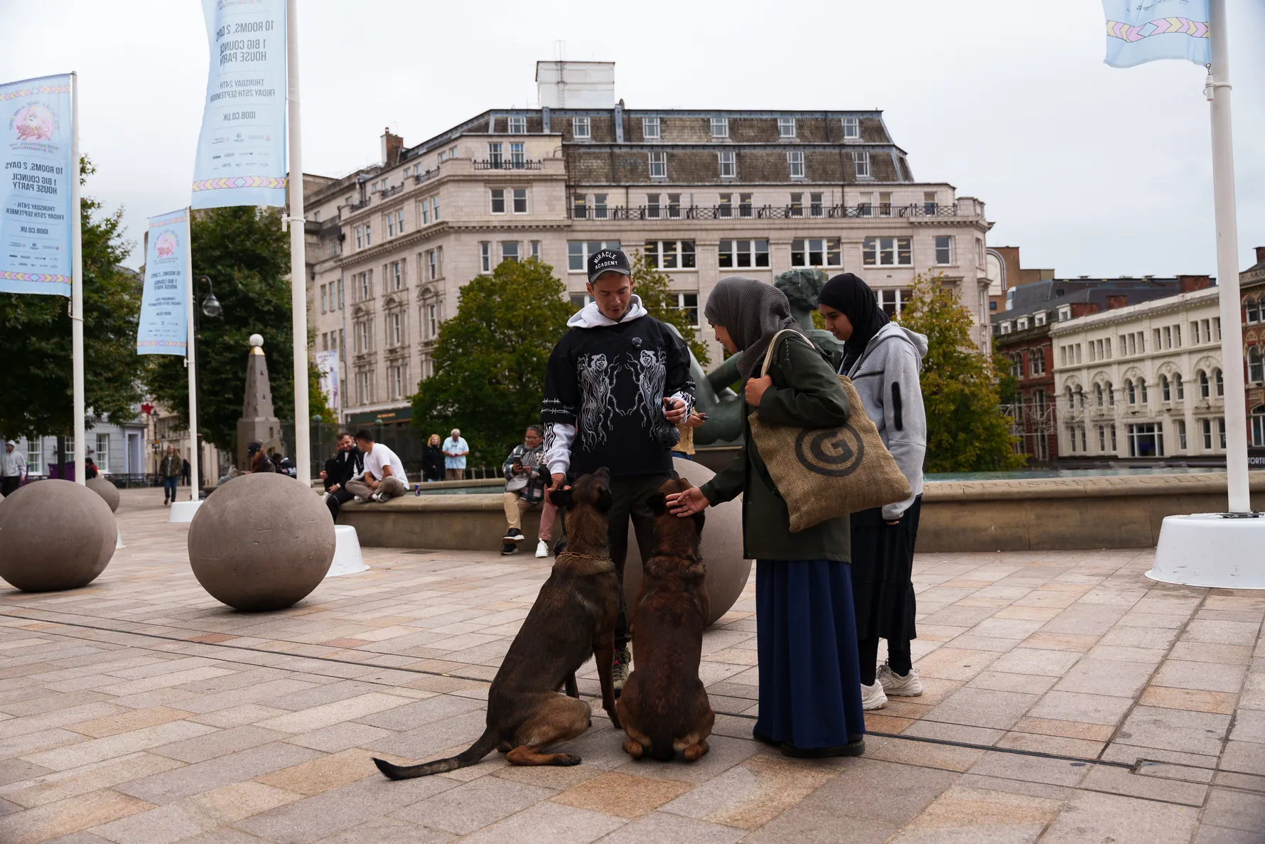 Andrejus coaching his dogs near pedestrians in a public square