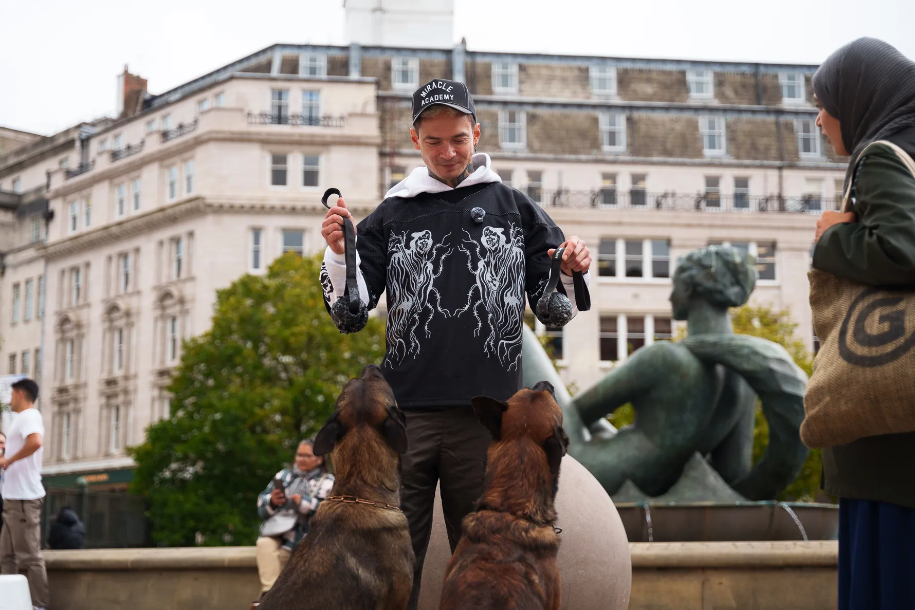 Andrejus giving a cue to working dogs in a Birmingham public square