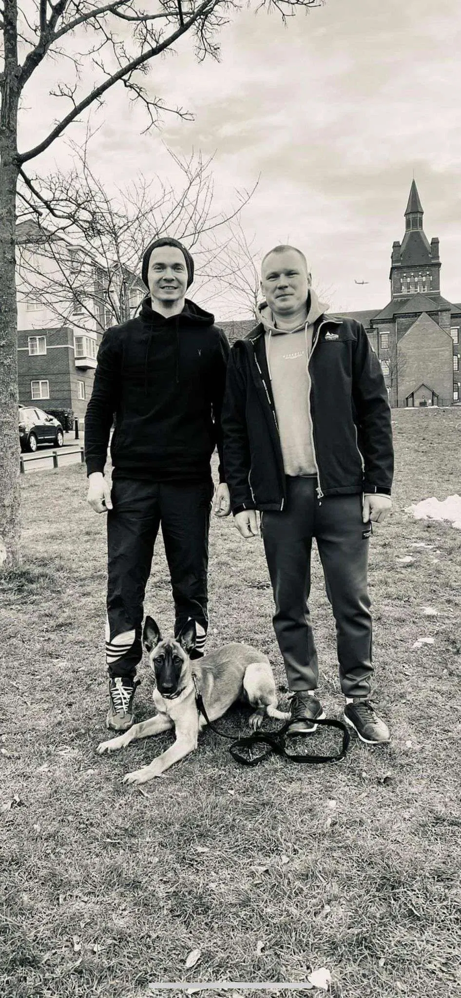 Group photograph with dog handlers and trained dogs outdoors